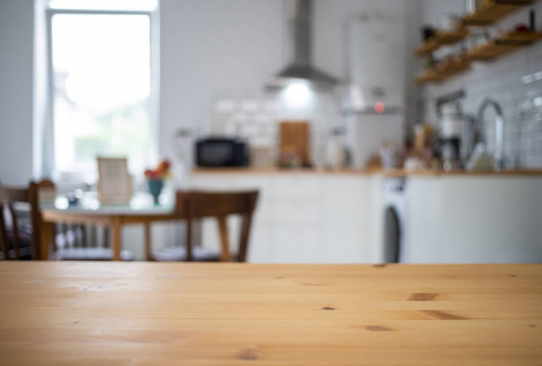empty wooden tabletop and blurred kitchen mock up for product display - Foto, afbeelding