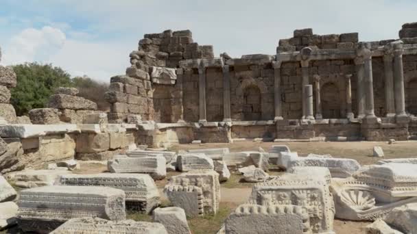 Pan shot of ruins or remains of columns at Devlet Agorasi in Side, Turkey. 4K footage, Beautiful old archeological park - Felvétel, videó