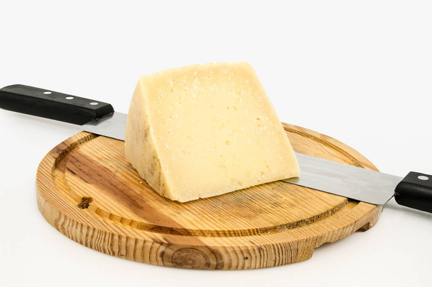 Piece of cheese on wooden board with knife. Portion of aged cheese, typical of Zamora, Spain, isolated on white background. - Foto, Bild
