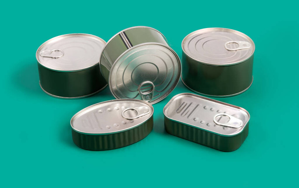 Unopened green cans with food inside on green background. Horizontal photography made in studio. - Foto, immagini
