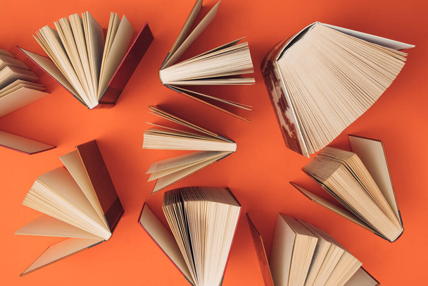 Творческий узор из книг на ярко-оранжевом фоне. Концепция образования и знаний. Плоский лежал. - Фото, изображение