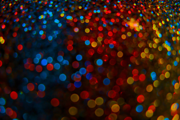 Shiny Festive Background. Lots of Flashing colorful spots.colorful bokeh background. Multicolored garlands on a black background. Christmas background. Glowing bokeh.soft focus. - Foto, Bild