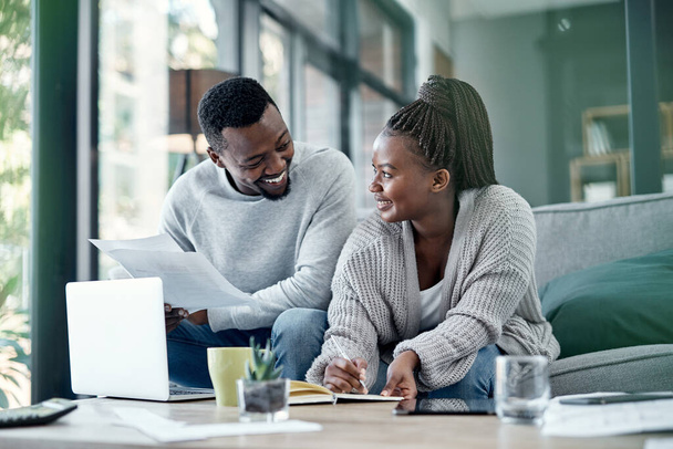 Couple planning finance investments, insurance and banking bills papers together at home. Happy husband and young wife smiling over their financial budget report information and household money plan. - Photo, Image