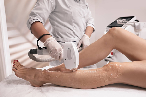 Woman undergoing laser epilation procedure in beauty salon, closeup - Fotografie, Obrázek