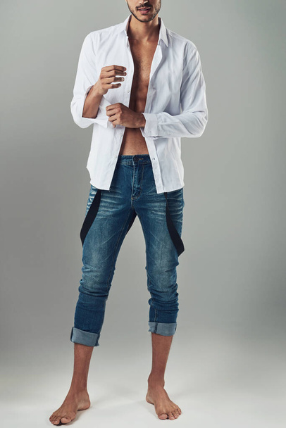Know your style and wear it well. Studio shot of a handsome young man wearing jeans and a white shirt against a grey background - Фото, зображення