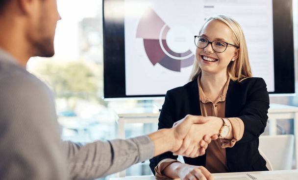 Lets keep the momentum going. a young businesswoman and businessman shaking hands during a meeting in a modern office - Foto, Bild
