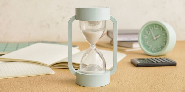 Hourglass on table. Time management concept - Фото, изображение