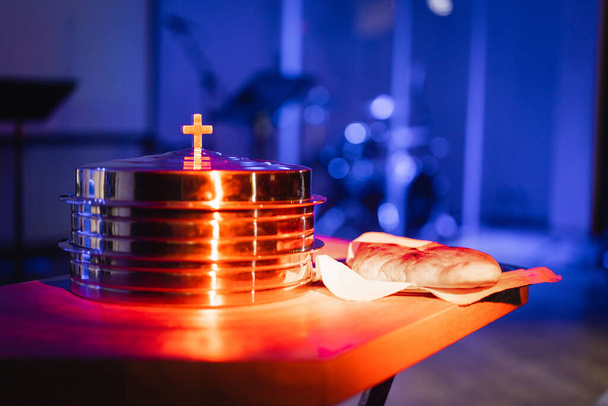 The process of breaking bread in the modern church. Breaking bread ceremony in protestant church. Religious tradition of breaking bread. Bread and wine. - Zdjęcie, obraz