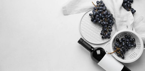 Bottle of red wine with fresh grapes on white background with space for text - Photo, Image