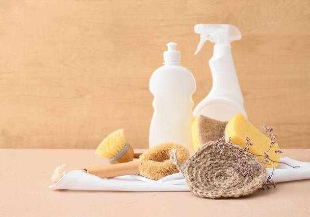 Set of cleaning supplies and bottles on color table - Foto, Imagem
