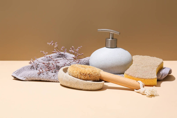 Household sponges, towel and pump bottle on color background - Foto, afbeelding