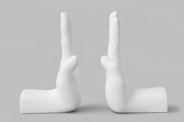 Bookend in shape of hands on grey background - Foto, afbeelding