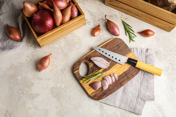 Wooden board with cut onion and knife on light background - Foto, immagini