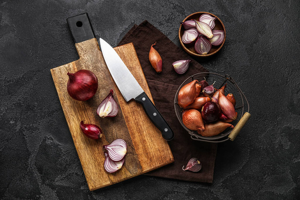Composition with wooden board of red onion on dark background - Foto, Bild