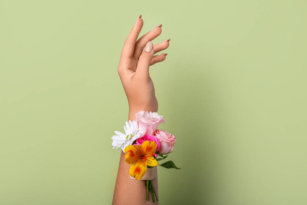 Γυναίκα με όμορφα λουλούδια και κολλητική ταινία σε πράσινο φόντο - Φωτογραφία, εικόνα