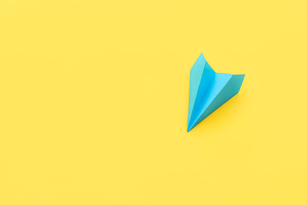 Blue paper plane on yellow background - Foto, immagini
