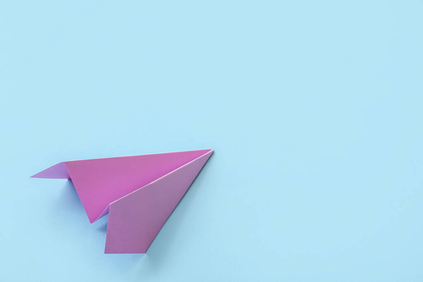 Lilac paper plane on blue background - Foto, imagen