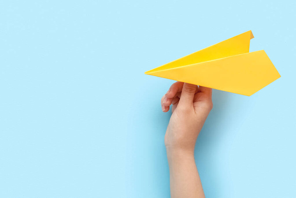 Woman with yellow paper plane on blue background - Foto, Bild