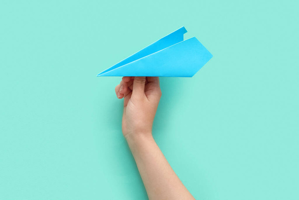 Γυναίκα με μπλε χάρτινο αεροπλάνο στο φόντο χρώμα - Φωτογραφία, εικόνα