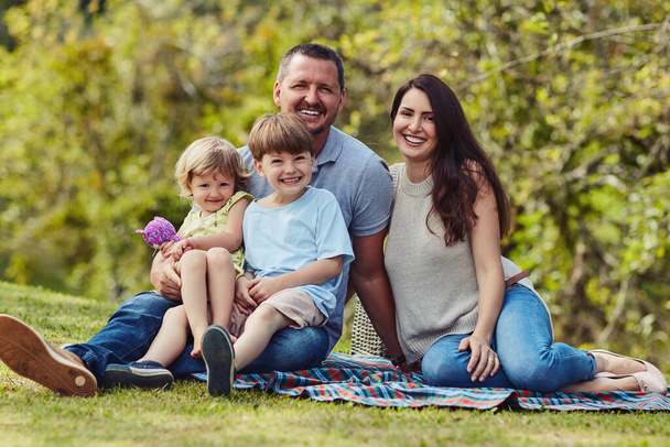 Family time means the absolute world to us. Portrait of a happy family bonding together outdoors - Foto, imagen