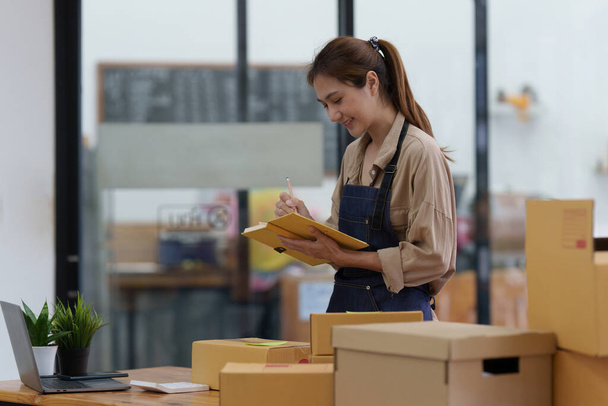 Atraktivní asijské malé a střední podniky obchodní žena kontrolní objednávky ve skladu. - Fotografie, Obrázek