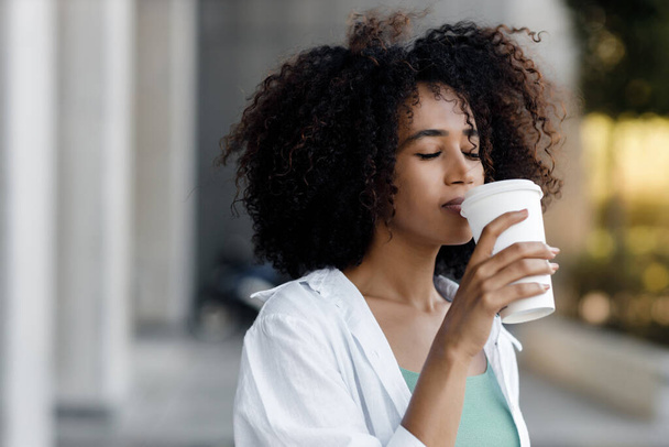 pretty young afro woman with coffee outdoors. High-quality photo - Fotografie, Obrázek