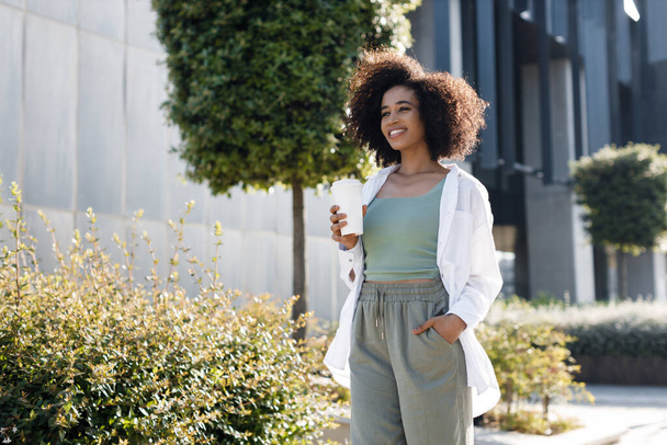 pretty young afro woman with coffee outdoors. High-quality photo - Foto, Bild