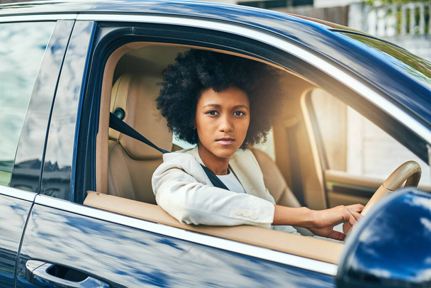 This traffic is making me go nowhere. Portrait of a confident young businesswoman on her way to work while driving in a car during the day - Foto, immagini