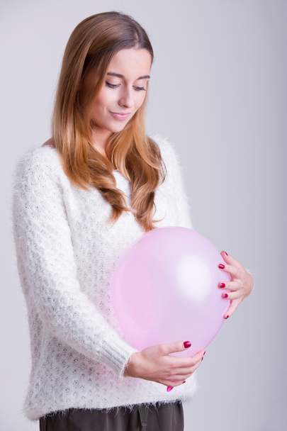 Mulher segurando um balão em sua barriga
 - Foto, Imagem