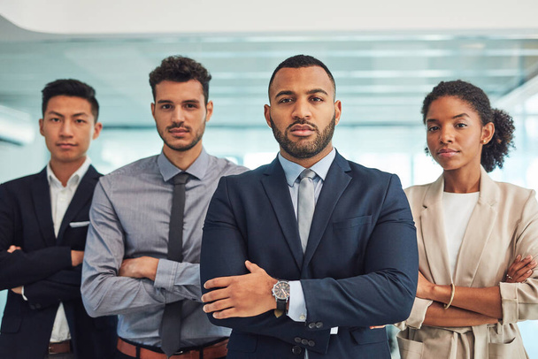 They are the best candidates for the job. Portrait of a group of confident young businesspeople standing with their arms folded inside of the office at work during the day - Foto, Imagem