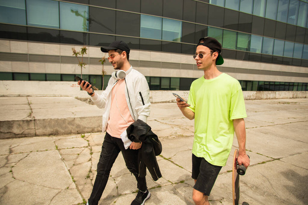 Two handsome male friendsa re walking together while talking - Valokuva, kuva