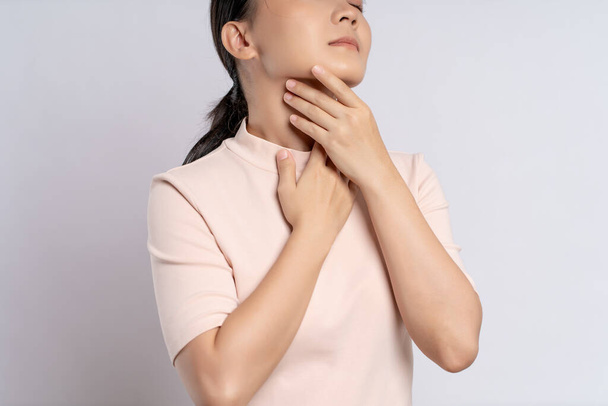Asian woman was sick with sore throat, coughing sneezing and standing isolated on white background. - Foto, Bild