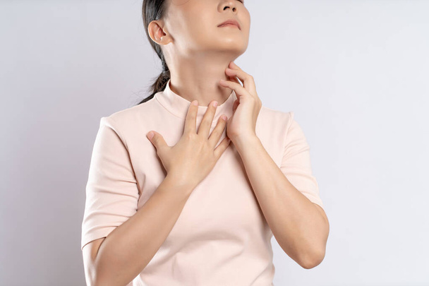 Asian woman was sick with sore throat, coughing sneezing and standing isolated on white background. - Photo, Image