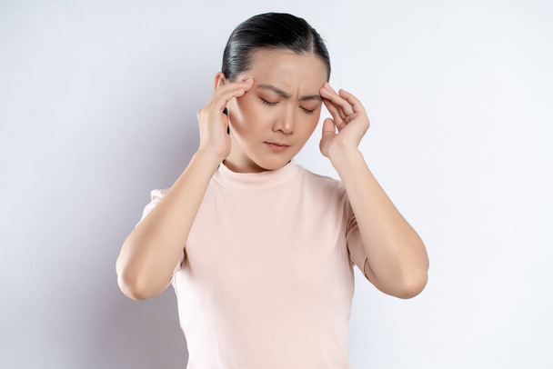Asian woman was sick with headache touching her head and standing isolated on white background. - Foto, Imagen