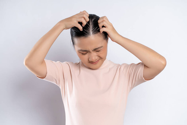 Asian woman was sick with irritate scratching her head, standing isolated on white background. - Valokuva, kuva