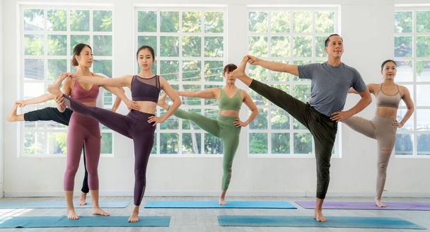 Тренер по йоге из Азии и ее ученица позиционируют йогу как основную позицию в классе в фитнес-центре - Фото, изображение