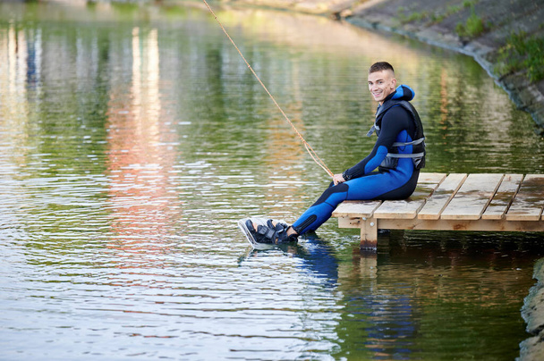 Wakeboarder ετοιμάζεται για σέρφινγκ στη λίμνη. Νεαρός σέρφερ που κάνει wakeboarding στο πάρκο. Θαλάσσια σπορ, έννοια υπαίθρια δραστηριότητα. - Φωτογραφία, εικόνα