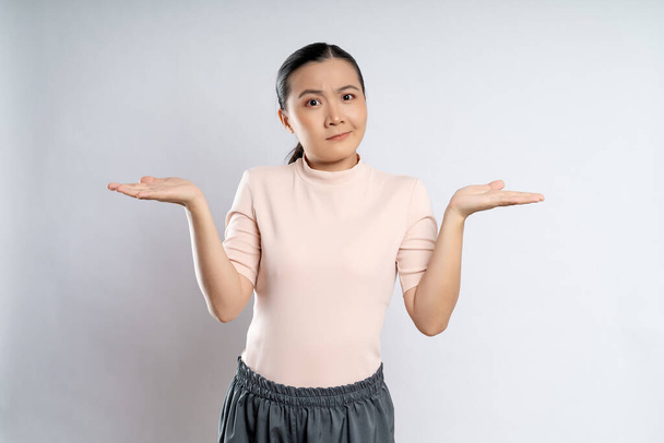 Asian woman thinking about problem, worried and confused standing isolated on background. - Photo, Image