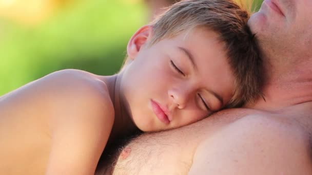 Padre e hijo juntos niño pequeño tomando una siesta con papá al aire libre - Imágenes, Vídeo