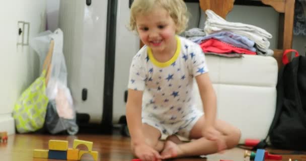 Happy cute candid toddler playing with toys in the evening wearing pajamas - Filmmaterial, Video