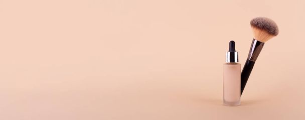 Liquid foundation cream unbranded bottle with makeup brush. Facial correction, liquid concealer, tone, bb, cc cream skincare product on beige background. Feminine cosmetics accessory with copy space - Foto, Imagem