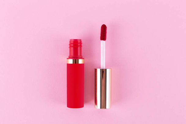 Applicator with liquid red lipstick tube on pink background. Space for text. Mockup - Фото, зображення
