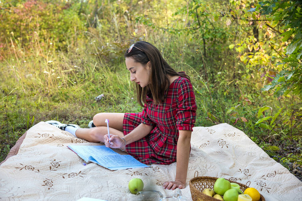 όμορφη γυναίκα χαλαρώστε στη φύση ξαπλωμένη σε κουβέρτα και διαβάζοντας ένα βιβλίο. τρόπος ζωής - Φωτογραφία, εικόνα