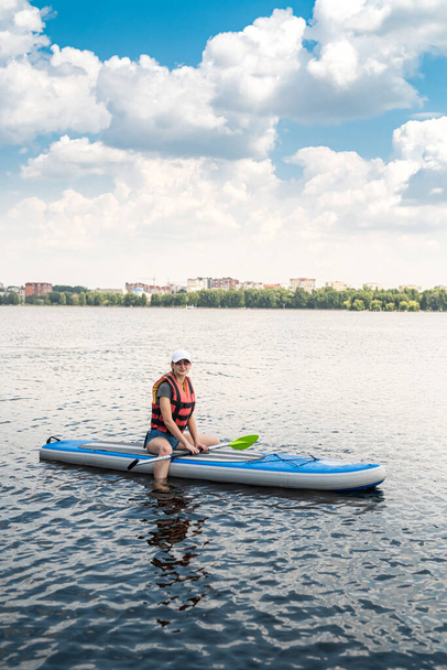  Молодая женщина носить спасательный жилет весла посадка на красивом озере в летний жаркий день, активный образ жизни спорта и расслабиться - Фото, изображение