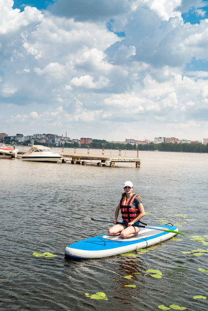 женщина отдыхает на веслах на заливе или городском озере. идеально провести жаркий летний день на природе - Фото, изображение