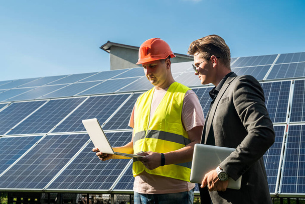 v blízkosti solárních panelů, zaměstnanec ukazuje pracovní plán na šéfa - Fotografie, Obrázek