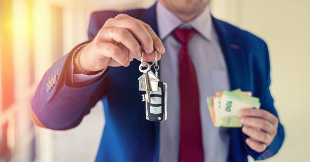 business man hold car and house key with euro money. investment for future - Photo, image
