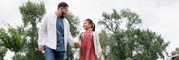 Cheerful asian father and daughter holding hands in park, banner  - Foto, Imagem