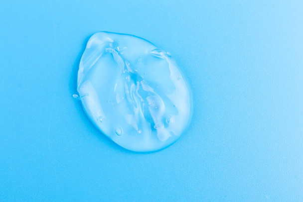 Moisturizing transparent face cream gel smeared isolated on blue background. - Fotografie, Obrázek