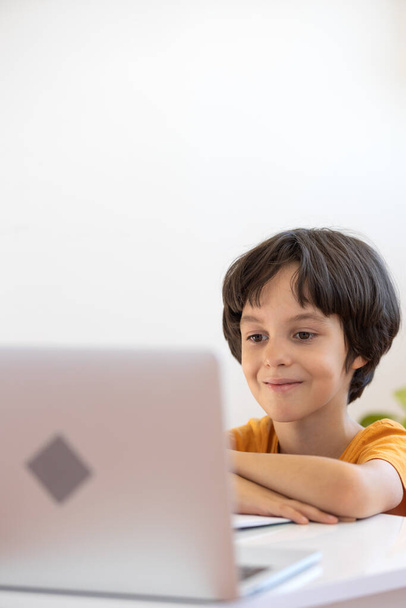 Aprendizaje a distancia online. un niño con un ordenador se comunica por videoconferencia con un profesor y un grupo de clase. El niño se comunica en línea. - Foto, imagen